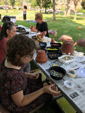 community members ceating mosaic pots 